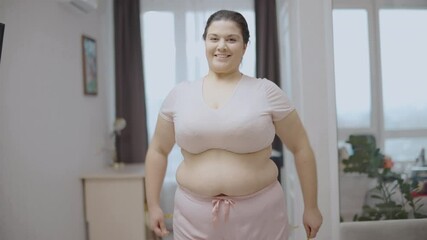 Glad plump woman measuring waist by tape, effective diet, weight loss results
