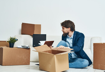 A man sits boxes with things unpacking a new professional job