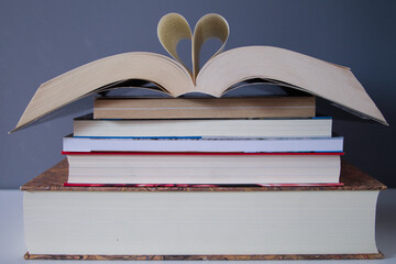 group of books and above one ope in the middle with two pages forming a heart for the love of reading on the international day of the book