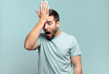 young handsome adult man raising palm to forehead thinking oops, after making a stupid mistake or...