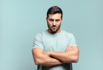 young handsome adult man feeling displeased and disappointed, looking serious, annoyed and angry...