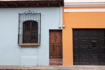 two color wall of clean colonial house, with wooden doors and classic balconies