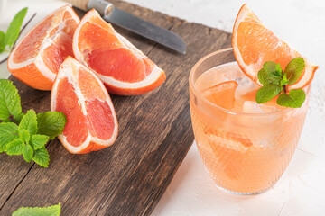 Grapefruit juice with mint in glasses on the table. Refreshing summer cocktail.