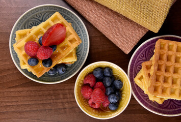 Homemade traditional belgian waffles with fresh fruits berries top view stock images. Fresh waffles with berries on the table photo. Sweet breakfast with waffles and fruit images