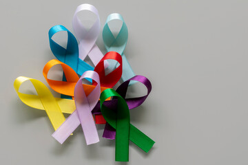 several colored ribbons with bows representing campaigns to prevent diseases such as cancer,...