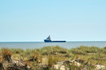 Boat leaves Great Yarmouth Outer Harbour. From South Beach, looking out to sea a service boat...