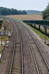 Fototapeta na wymiar Close view of signals & curve in freight train track near Felixstowe. Double curved rail line towards Felixstowe in Trimley. Close view showing signals & ramp for horses to use the bridge