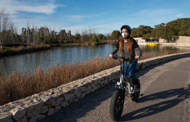 Girl for a ride with her electric bike in the park on a sunny day.