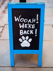 A "We're back" restaurant, bar, shop chalk board sign. Open for business, back to normal, opening notice. Taken during Covid-19, coronavirus lockdown.