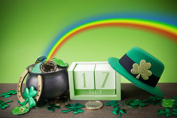 Happy St. Patrick's day. Shiny shamrocks, gold coins and leprechaun hat on a wooden background with...