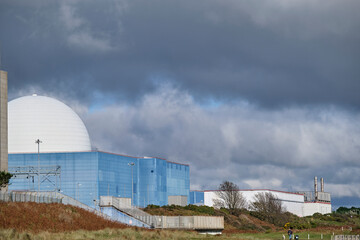 Moody dark clouds above Sizewell B reactor building in Sizewell, Suffolk.The white dome, blue...