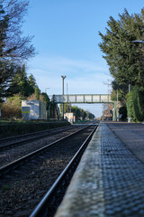 Fototapeta premium Trimley station platform, looking towards the level crossing & foot bridge.