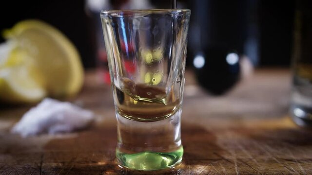 Primer plano chupito de tequila reposado, sal y rodaja de lim&oacute;n fondo negro