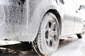 dirty car wheel in washing foam