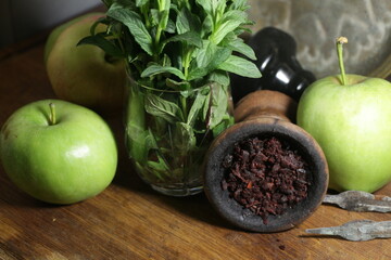 bowl with tobacco for hookah on a dark background. berries on a black table. hooka smoking
