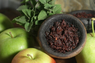 bowl with tobacco for hookah on a dark background. berries on a black table. nargile smoking