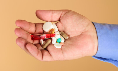 Man hands with pills. Medicine, treatments and healthcare. Tablets in hand of patient.
