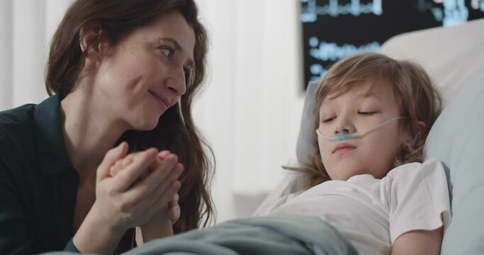 Smiling mother visiting sick preteen son in hospital