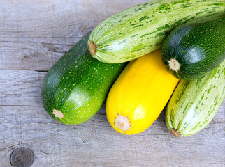 Zucchini on wooden background. Yellow and green zucchini.