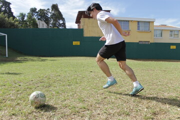 Deportista jugando y dominando un balón de Football