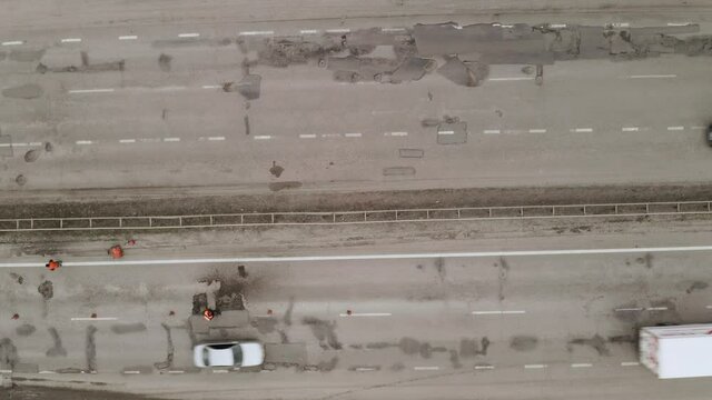 Road workers manually fill the pits and potholes on the road surface. Workers repair highway surface - aerial drone Overhead panorama Shot