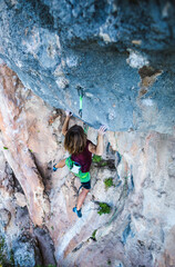 A young athlete climbs a rock