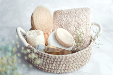 woven basket with natural body care products - sponge, towel, loofah, soap, body brush