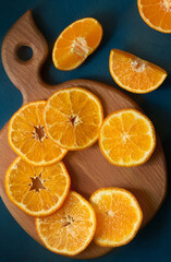 Tangerine or mandarin fruit sliced on a wooden board, top view