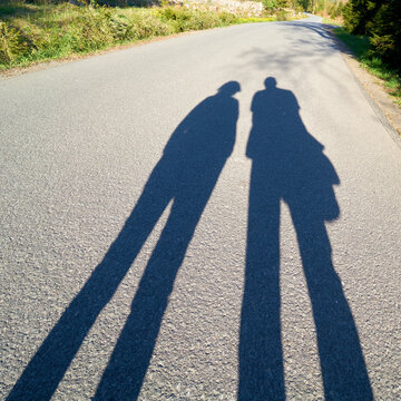 Schatten von zwei Menschen auf der Brockenstraße im Nationalpak Harz bei Schierke