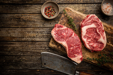 Variety of Fresh Raw Black Angus Prime Meat Steaks New York, Ribeye and seasoning on wooden background, top view