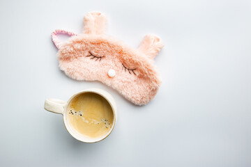 sleeping mask and coffee cup on white background. The concept of starting a new day, good morning or ending the day, late evening.