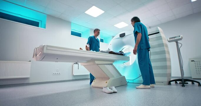 Male doctors escorting African American patient after CT scan