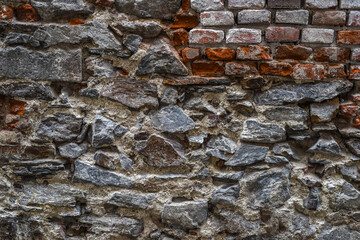 The wall is made of different stones. Stone background.