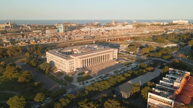 Aerial parallax shot of the Faculty of Law of University of Buenos Aires and Villa 31 at golden hour