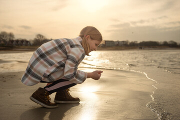 Portrair of happy beautiful child girl playing on Baltic sea beach