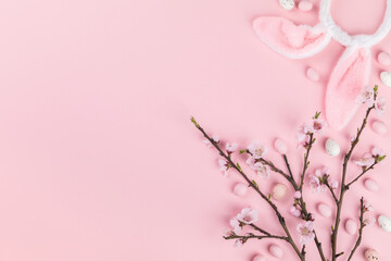 Easter composition painted eggs flowering cherry branchon a pink background.