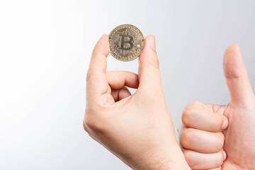 Plakat On a white background we look at a virtual currency, namely the cryptocurrency bitcoin, held in the right mine. 