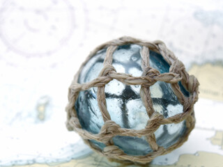 Japanese glass fishing float on nautical chart © Danita Delimont
