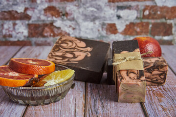 Natural handmade soap with chocolate and orange on a wooden countertop.
