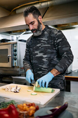 Professional military base chef or cook preparing delicious tasty meal with fresh salmon fish and salad.