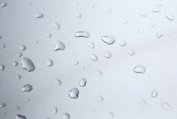 Drops in row on metal surface with shallow depth of field