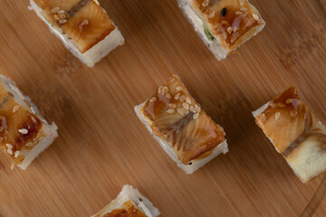 Wooden board of dragon sushi rolls with eel background