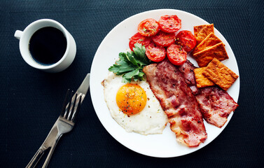 English breakfast - fried eggs, tomatoes, bacon and crackers