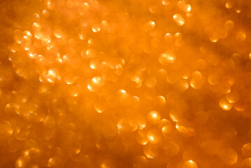 Abstract blurred orange background with glowing bokeh
