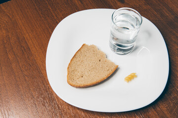 bread, pasta and vodka on white plate on wooden background