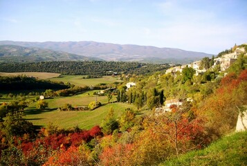 Fototapeta na wymiar Paysage ensoleillé d'une vallée verdoyante et de collines boisées. Saignon, Lubéron, France.