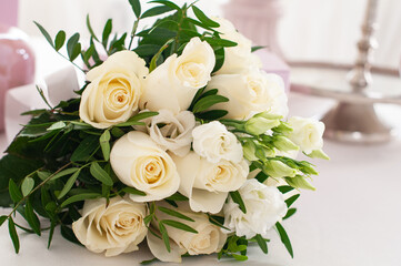 Wedding bouquet of white roses on the white table