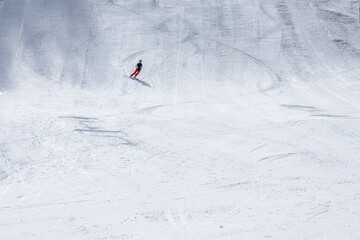 Beautiful texture created by skiers descending the mountain. Sportsman descends along the snowy slope of a ski resort .The concept of winter sports. High quality photo