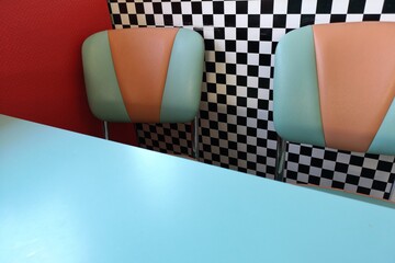 part of table and chair in burger bar in front of checkered wall