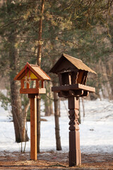Wooden bird feeder in the park in the cold season